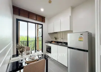 Modern kitchen with sleek cabinets and dining area overlooking a scenic view