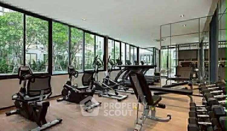 Modern gym with state-of-the-art equipment and large windows offering garden views.
