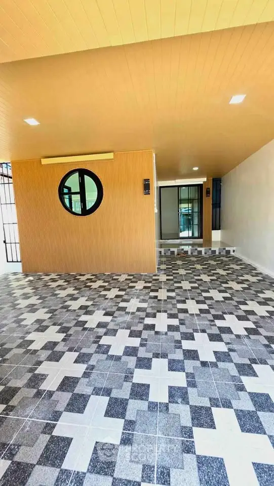 Modern entrance with stylish tile flooring and circular window design