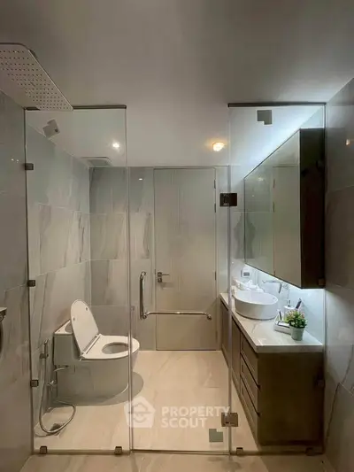 Modern bathroom with glass shower enclosure and sleek fixtures
