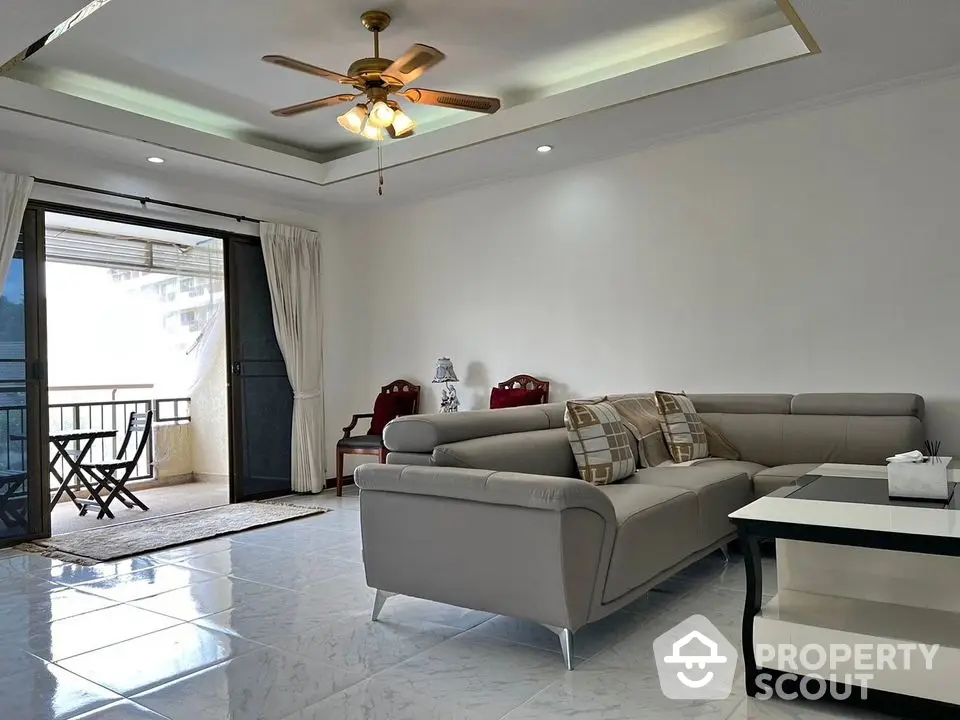 Spacious living room with modern sofa and balcony access in elegant apartment.