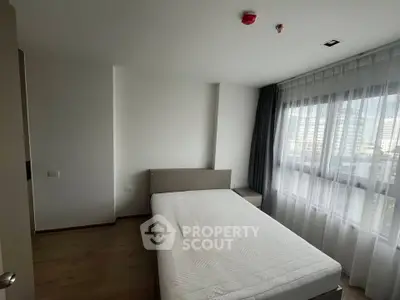 Spacious bedroom with large window and modern design in urban apartment