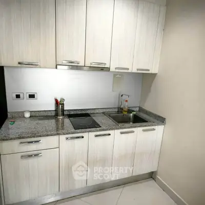 Modern compact kitchen with sleek cabinets and granite countertop