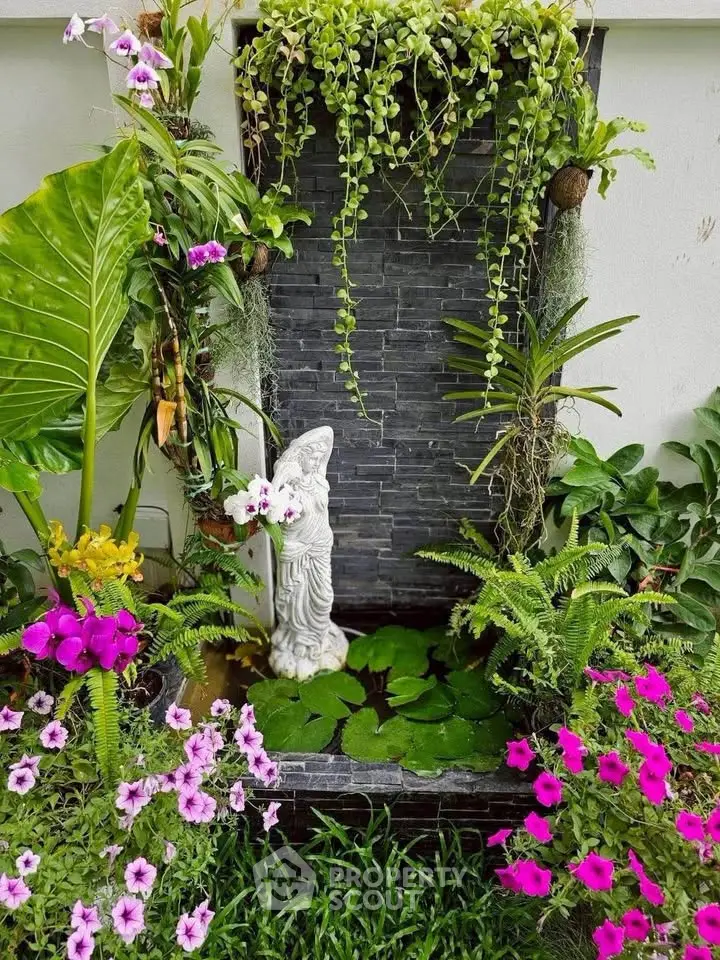 Charming garden with lush greenery and vibrant flowers surrounding a decorative water feature.