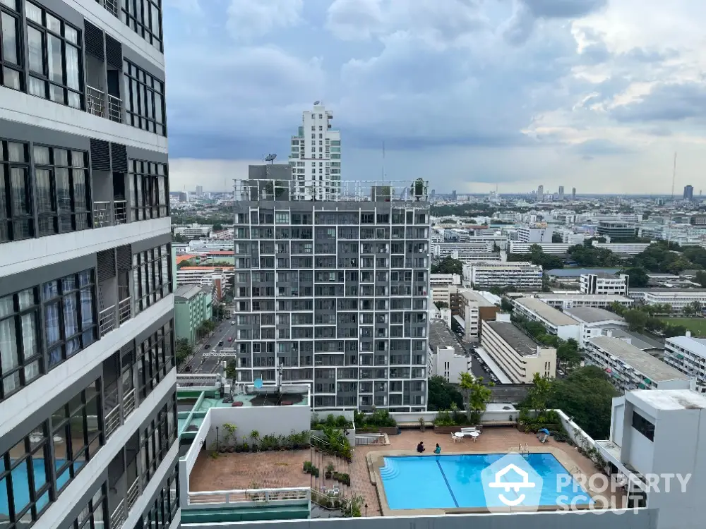 Stunning city view from high-rise building with pool and modern architecture.