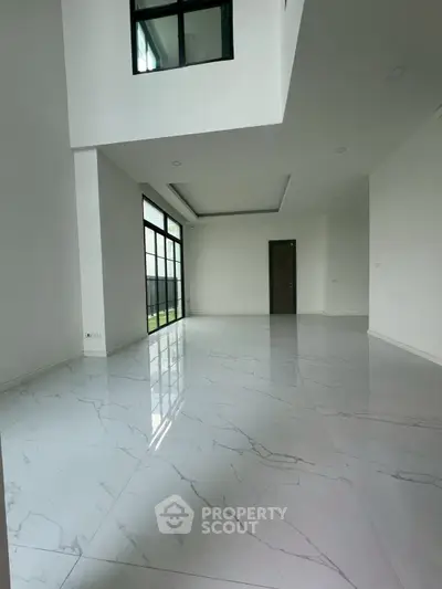 Spacious modern living room with high ceilings and large windows