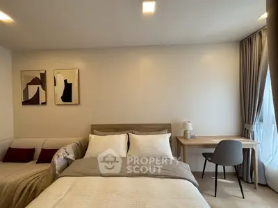 Modern bedroom with cozy bed, stylish decor, and natural light from large window.