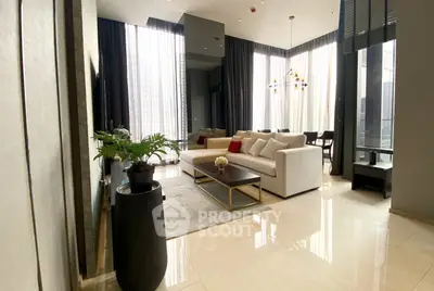 Luxurious modern living room with high ceilings and elegant decor in a high-rise apartment.