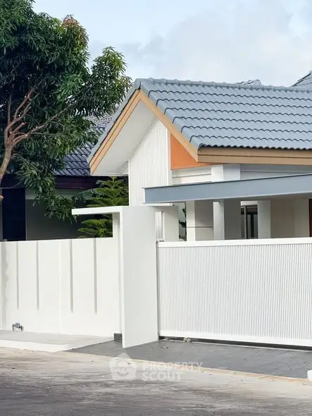 Modern suburban house with stylish roof and white fence