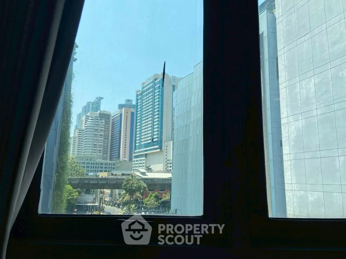 Stunning urban view from a window showcasing modern skyscrapers and cityscape.