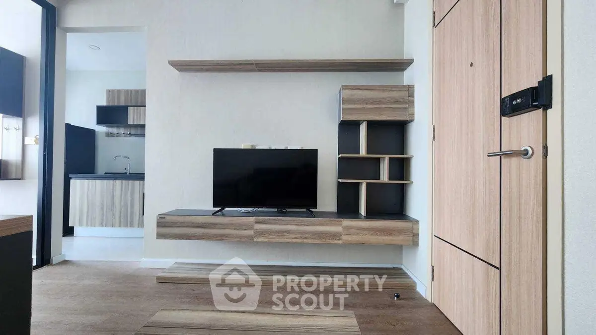 Modern living room with sleek wooden TV unit and open kitchen layout