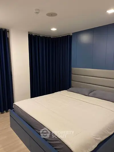 Modern bedroom with sleek blue accents and cozy lighting