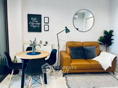 Stylish modern living room with leather sofa, round dining table, and chic decor accents.