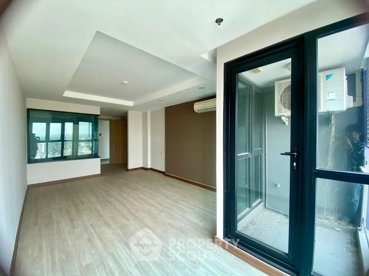 Spacious modern living room with large windows and balcony access