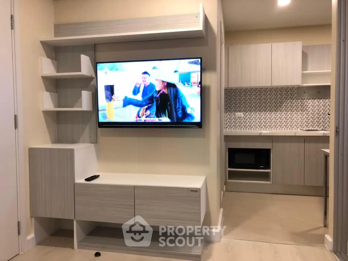 Modern living room with built-in TV unit and sleek kitchen design