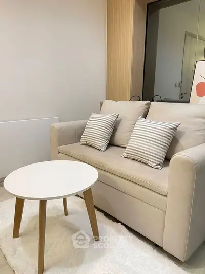 Cozy living room with beige sofa and modern round table, perfect for relaxation.