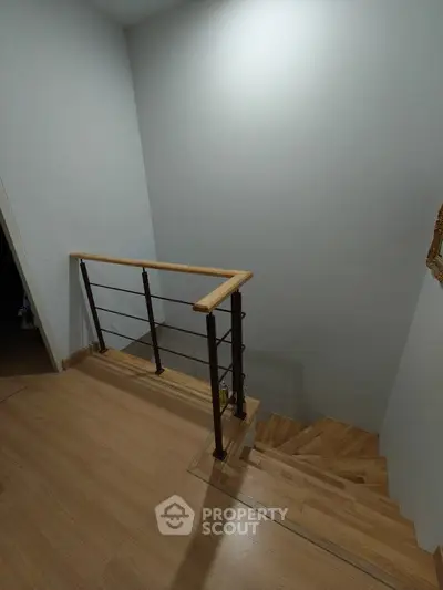 Modern staircase with wooden steps and metal railing in a minimalist interior design