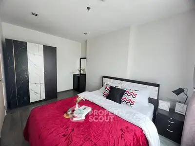 Modern bedroom with stylish decor and vibrant red bedding
