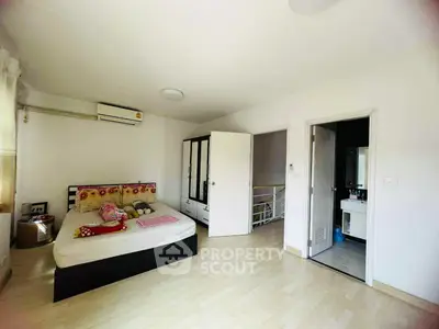 Spacious bedroom with modern decor and en-suite bathroom in a bright, airy home.