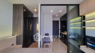 Modern studio apartment with sleek kitchen and cozy living area, featuring stylish furniture and ample natural light.