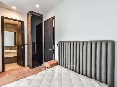 Modern bedroom with sleek design and ensuite bathroom in a stylish apartment.