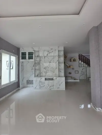 Spacious modern living room with marble accents and unique wall shelving, perfect for stylish urban living.