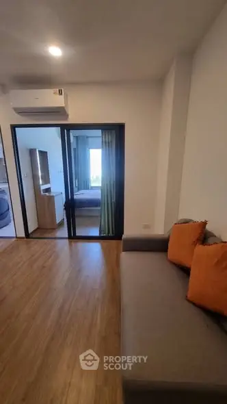 Modern living room with wooden flooring and cozy sofa in a stylish apartment.