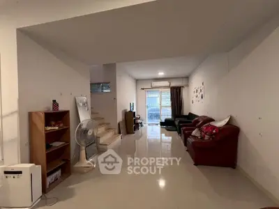 Spacious living room with modern furniture and natural light, perfect for family gatherings.