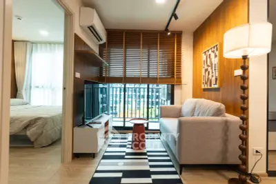 Modern living room with cozy sofa, stylish decor, and a view into the bedroom, perfect for urban living.