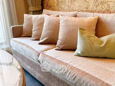 Luxurious living room with elegant beige sofa and plush cushions, perfect for relaxation and style.
