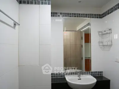 Modern bathroom with sleek sink and large mirror in stylish apartment.