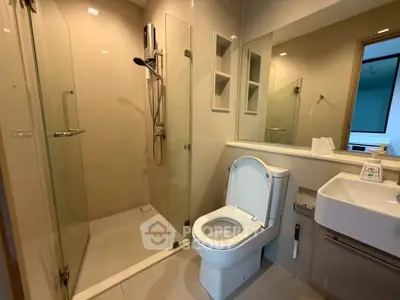 Modern bathroom with glass shower and sleek fixtures in contemporary apartment.