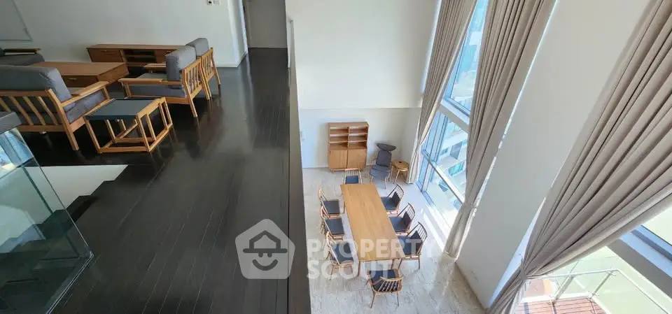 Spacious modern living and dining area with high ceilings and large windows.