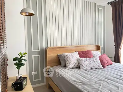 Charming bedroom with stylish decor and natural light, perfect for relaxation and comfort.
