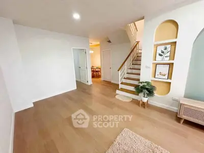 Spacious modern living room with wooden flooring and stylish staircase