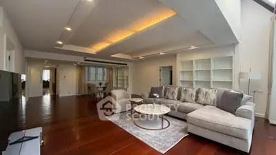 Spacious living room with elegant lighting and hardwood floors in luxury apartment