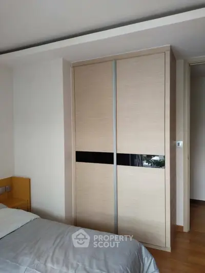 Modern bedroom with sleek sliding wardrobe and cozy bed setup