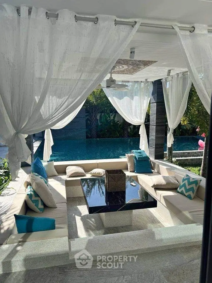 Luxurious outdoor seating area with pool view, featuring elegant curtains and modern design.