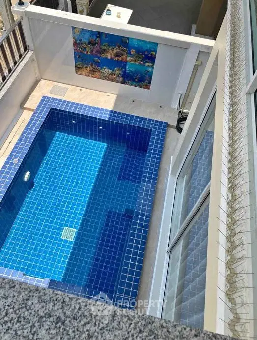 Luxurious private pool with vibrant blue tiles in modern home setting.