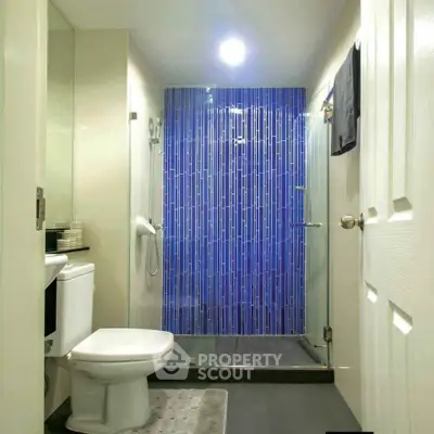 Modern bathroom with sleek design and vibrant blue tiled shower area.