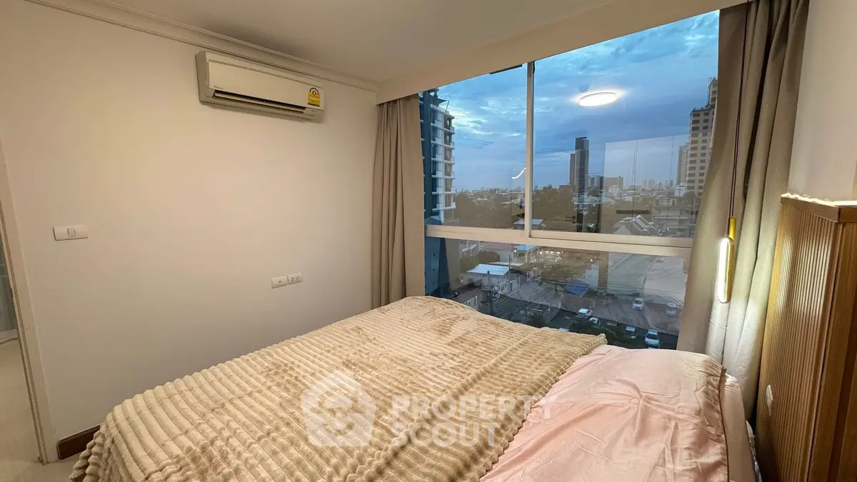 Cozy bedroom with city view and air conditioning in modern apartment