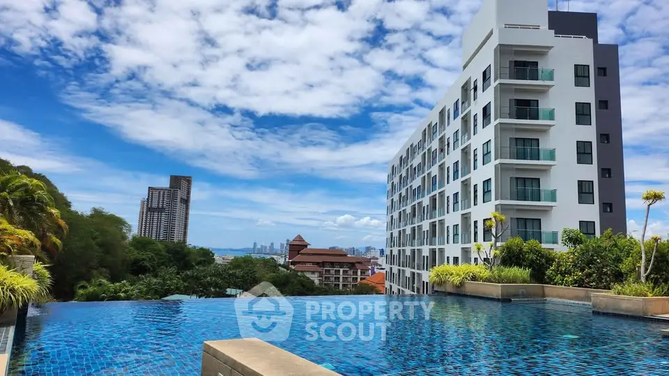 Luxurious apartment building with stunning infinity pool and city view.