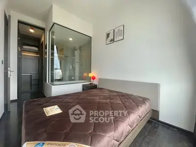 Modern bedroom with glass-walled bathroom and stylish decor
