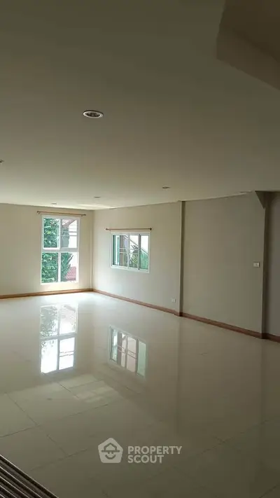 Spacious empty room with large windows and glossy tiled floor, perfect for customization.