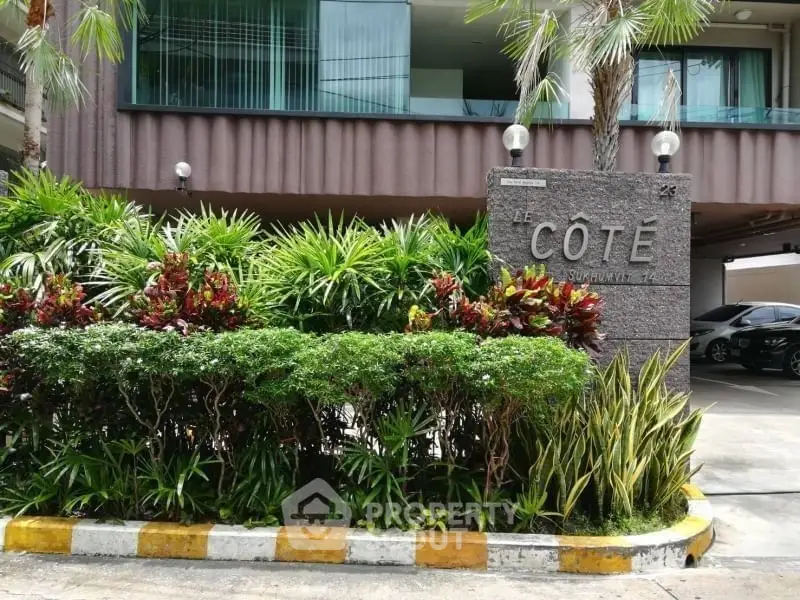 Stylish condominium entrance with lush greenery and modern design.