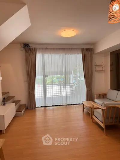 Spacious living room with modern furniture and large window view