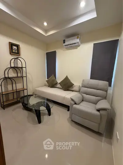 Cozy living room with modern furniture and air conditioning, perfect for relaxation.