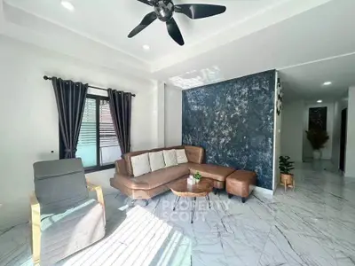 Modern living room with stylish decor and natural light, featuring a comfortable sectional sofa and elegant marble flooring.