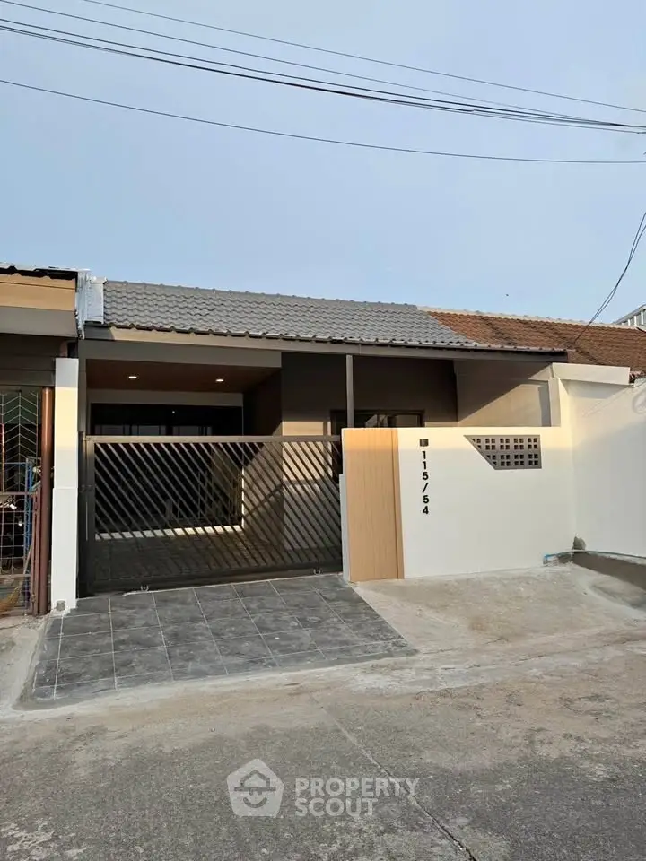 Charming single-story home with modern facade and gated entrance in a serene neighborhood.