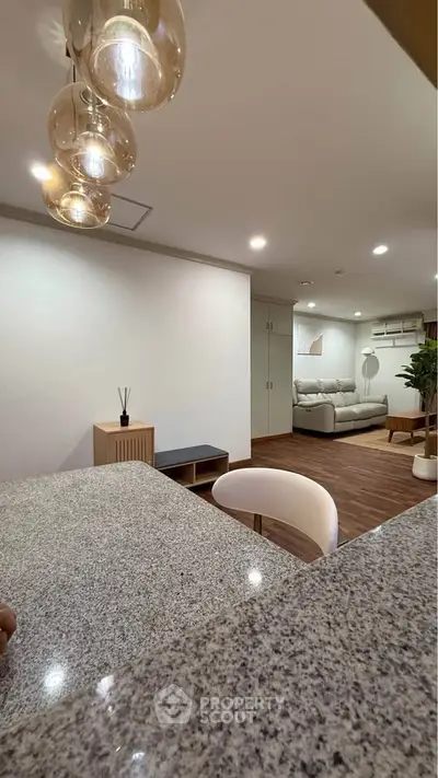 Modern open-concept living room with stylish lighting and cozy seating area.